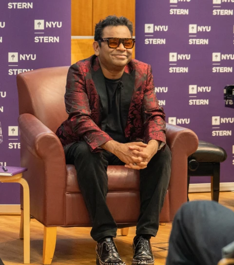 A. R. Rahman sitting in a chair smiling