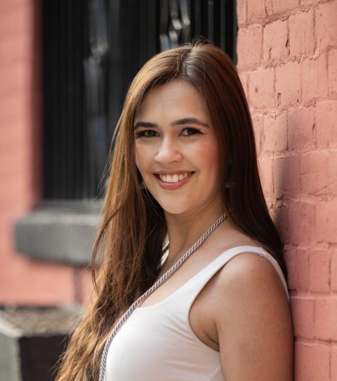 Sita is a woman with brown hair and is wearing a white shirt