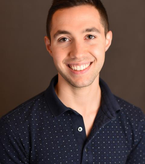 Adam Smith, Director, has brown hair and wears a blue shirt