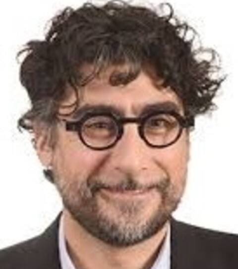 Headshot photo of Victor Araman. He has short curly hair and wears glasses and a suit.