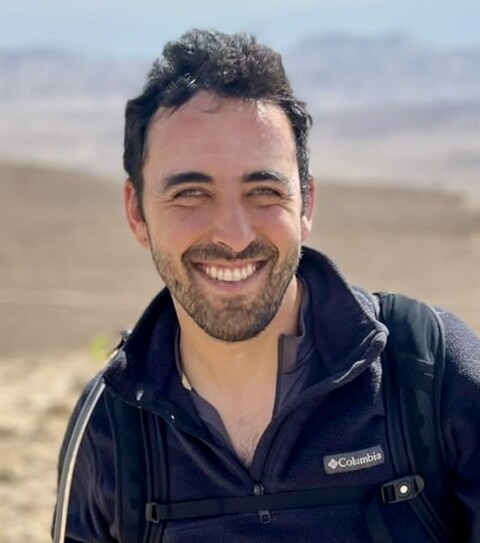 Man with brown hair in black jacket 