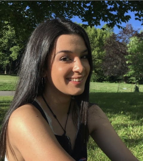 Headshot of Gaby sitting in a park