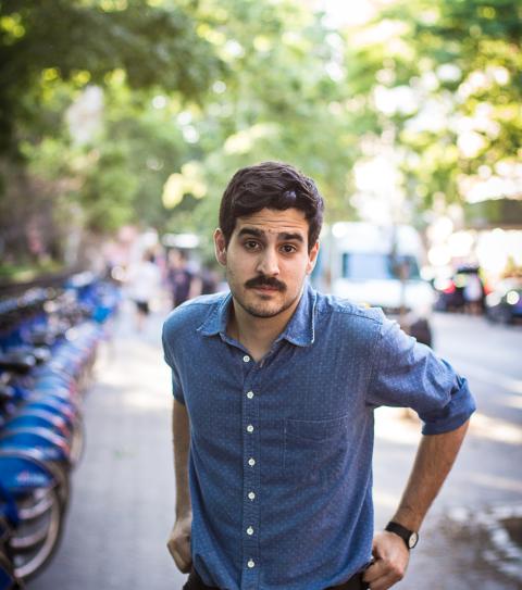 Alejandro standing outside in a tree lined street