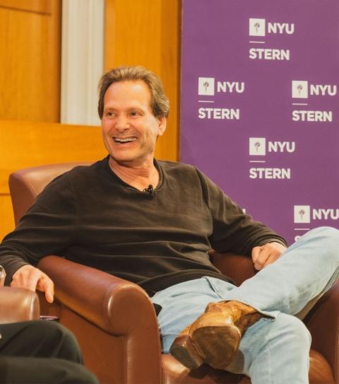 A picture of Dan Schulman sitting and laughing while talking with Dean Raghu Sundaram