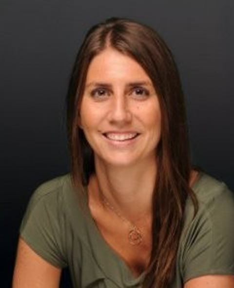 A portrait of Lindsay Unger - A dark haired white woman in a green shirt smiling at the camera