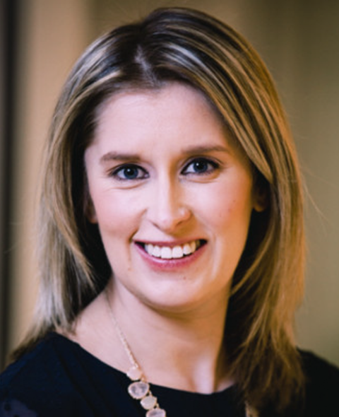 A portrait of Rachel Scherr - a blonde hair, white woman in a black shirt smiling at the camera