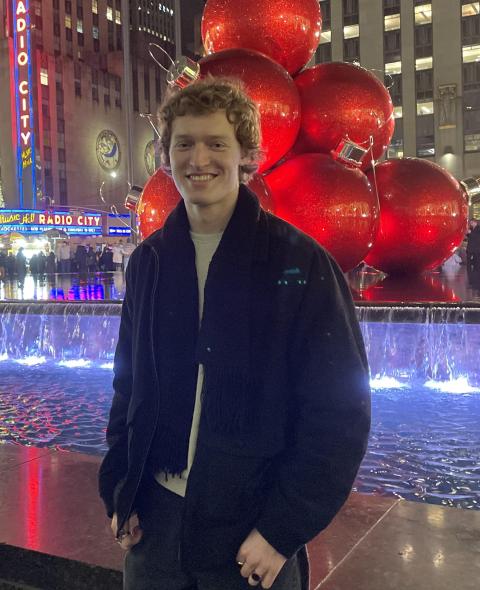 Ben smiling in front of a fountain 