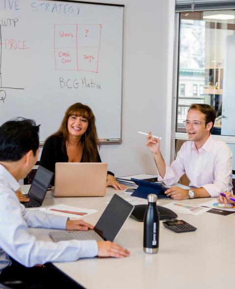 Students discussing around a classroom table