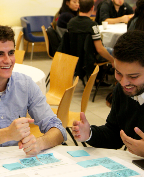 Two students discuss sticky notes during an interactive exercise