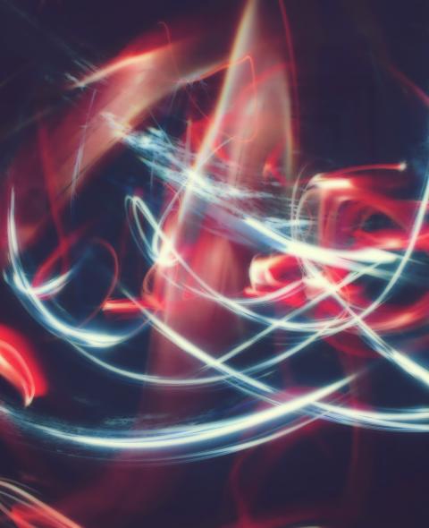 White and red light trails forming abstract patterns in a dark setting White and red light trails forming abstract patterns in a dark setting