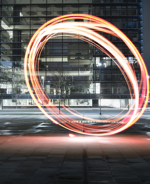 neon orange circles drawn vertically on a parking garage rooftop at night