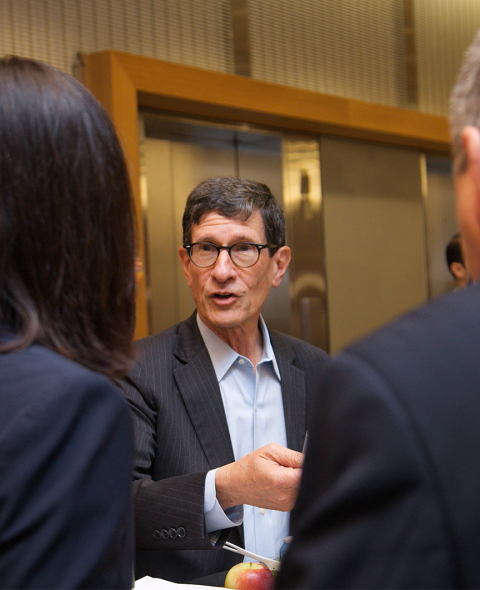 a person talking to two other people in the foreground