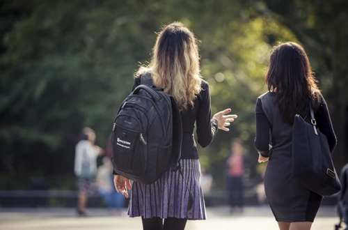 Two students walking through Washington Square Park