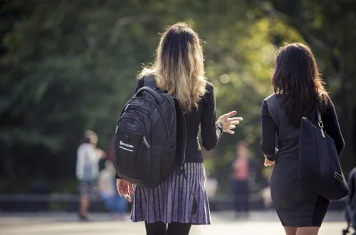 Two students walking through Washington Square Park