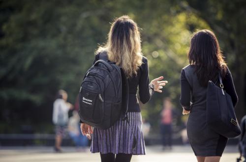 Two students walking through Washington Square Park