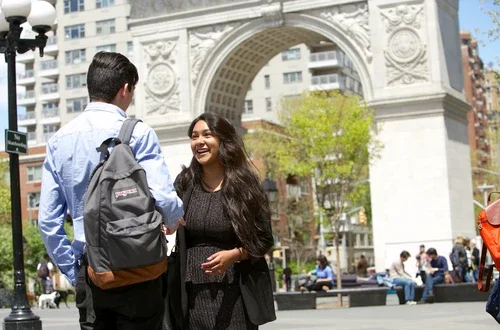Students chat in front of the arch at Washington Square Park