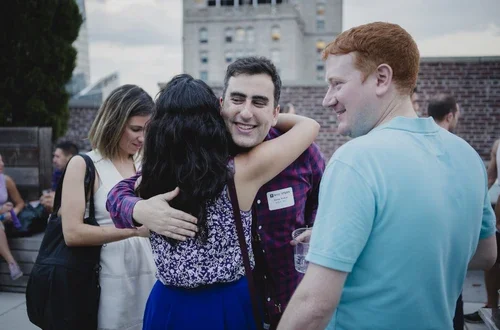 Alumni gather at an Outclass rooftop soiree