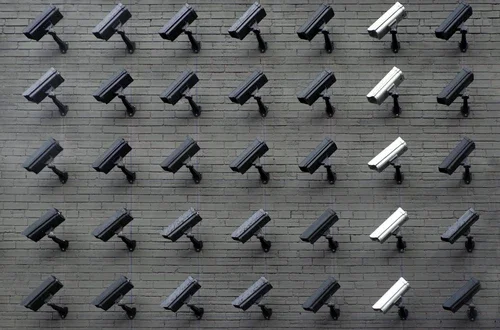 A brick wall filled with security cameras