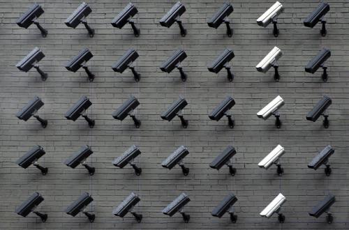 A brick wall filled with security cameras