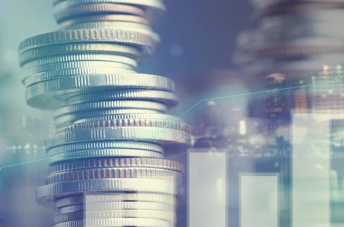 Double exposure of city and graph on rows of coins for finance and banking concept