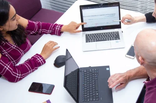 students gathered around laptops
