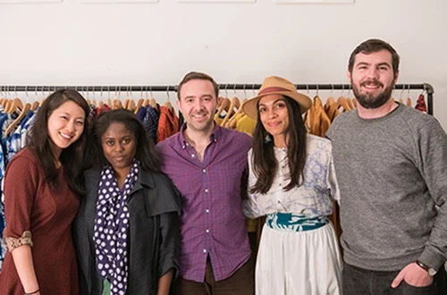 Students standing in front of clothing rack