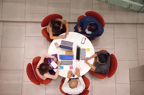 Overlooking students sitting at table working on laptops