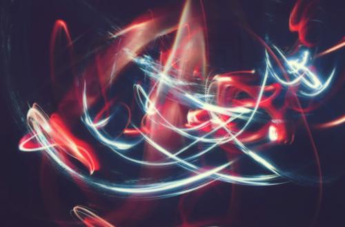 White and red light trails forming abstract patterns in a dark setting