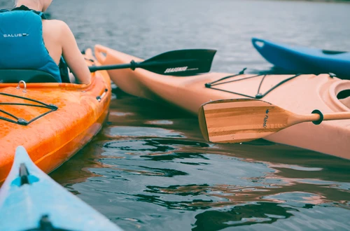 Person riding on orange kayak during daytime