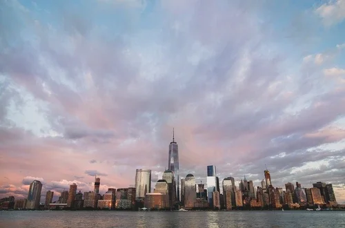 Assorted NYC buildings near body of water under cloudy sky