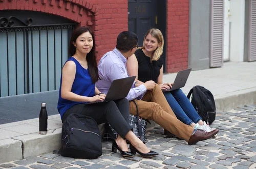 woman on curb with laptop