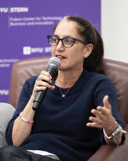 Liza Landsman holds a microphone and speaks