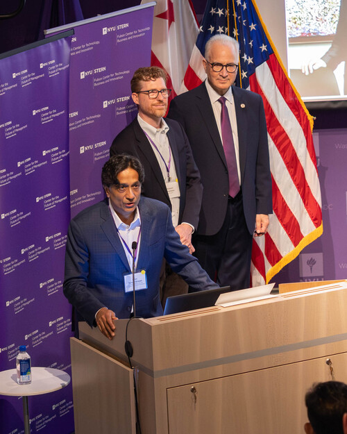 cohosts stand at podium