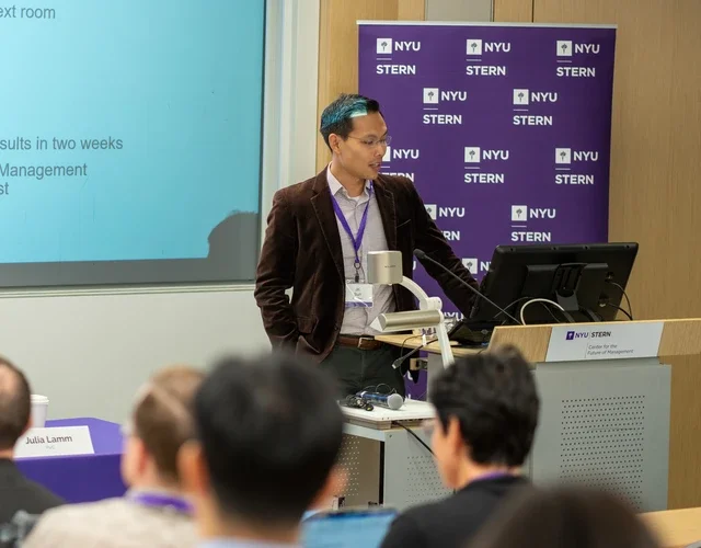 JK Suh standing in front of a podium