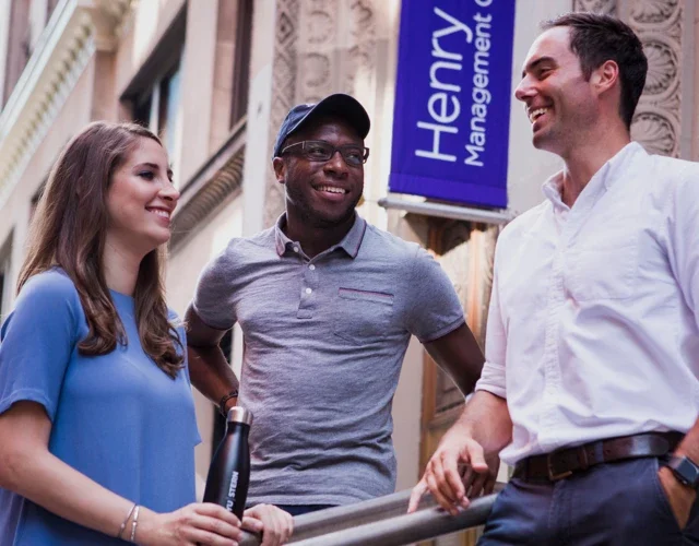Three people standing in front of the school building
