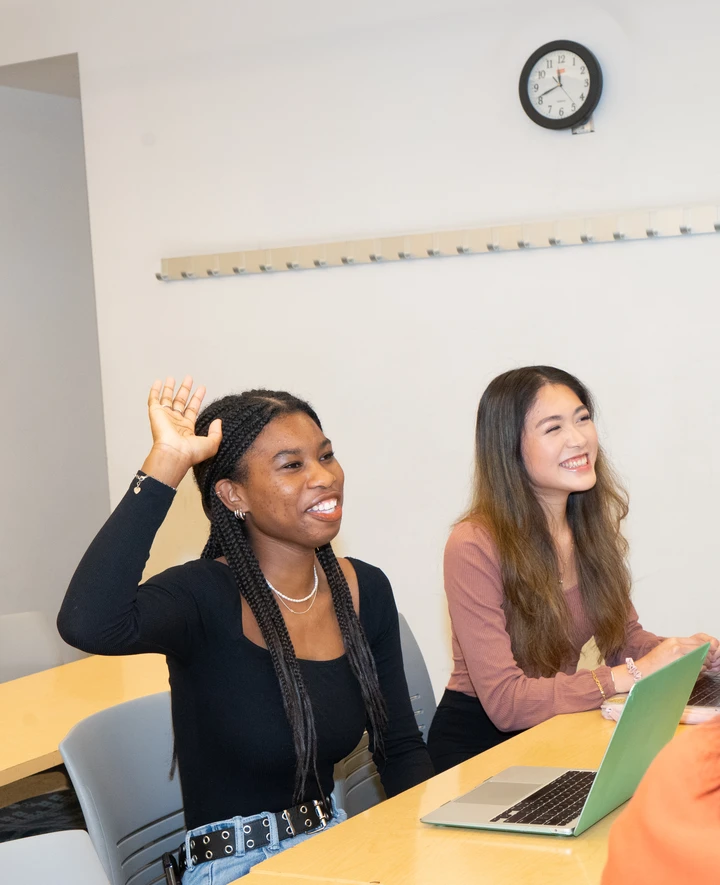 Student raising hand in classroom