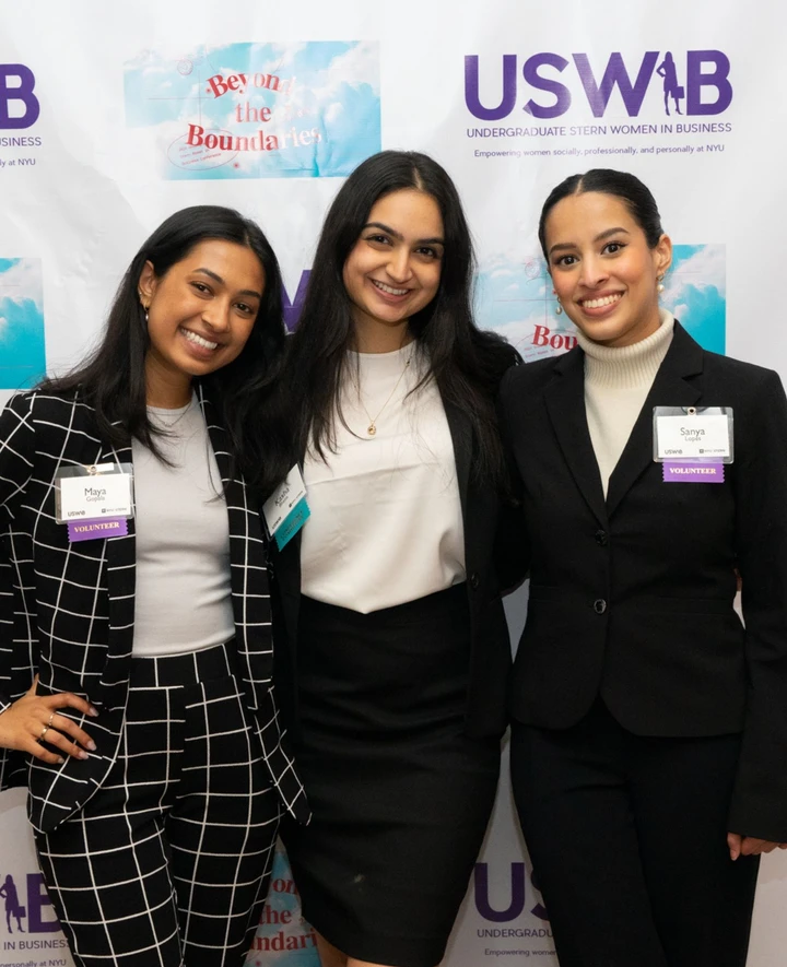 USWIB students pose in front of conference step and repeat