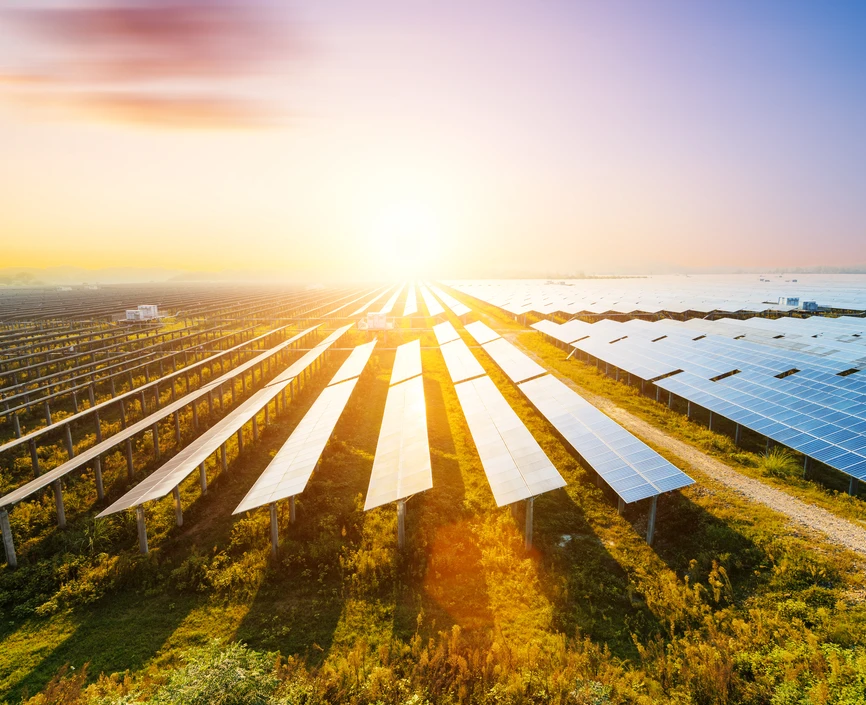 Photovoltaic modules reflect sunset light and clouds