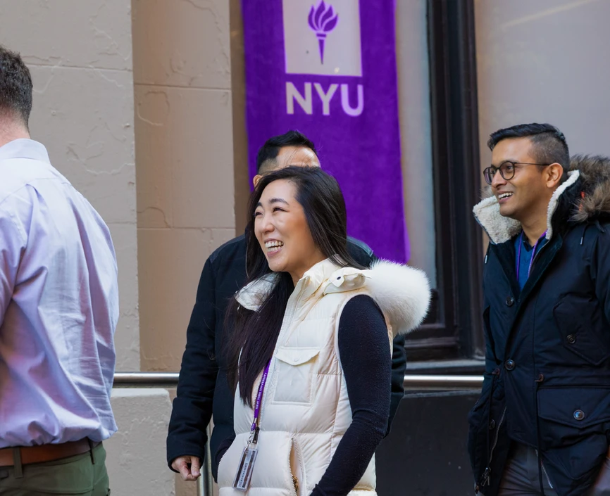 Executive MBA students with an NYU flag