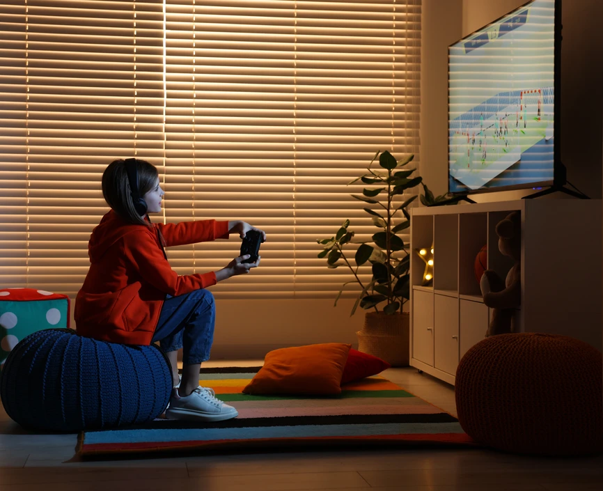 A child sitting in a darkened room playing a video game