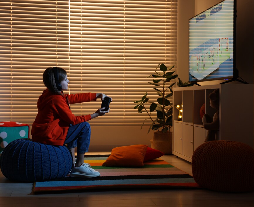 A child sitting in a darkened room playing a video game