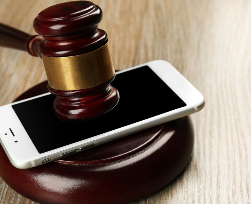 A gavel sitting on top of a smartphone