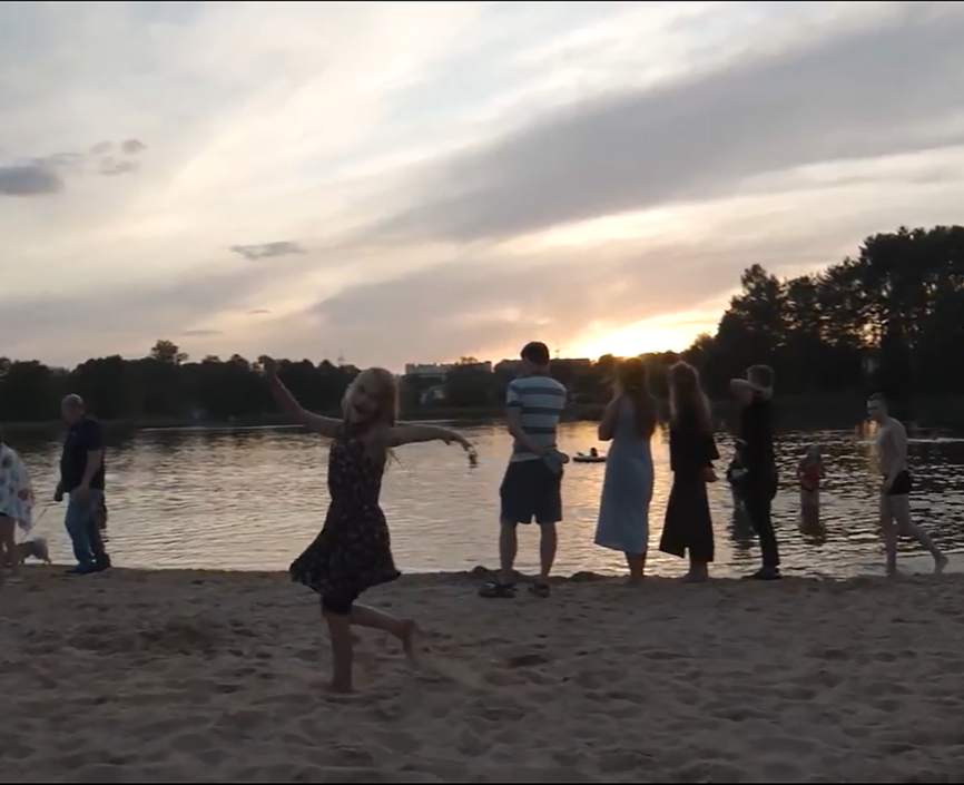 Families on the shore of a lake at sunset
