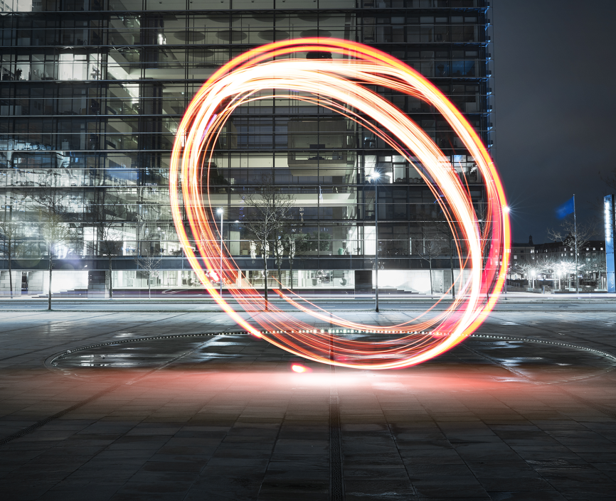 neon orange circles drawn vertically on a parking garage rooftop at night