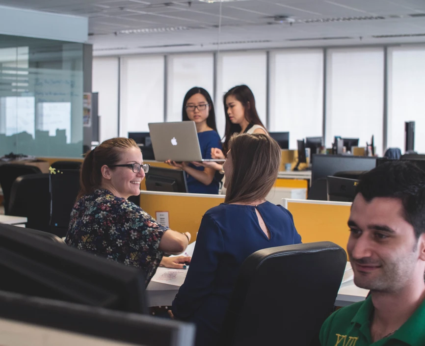 Men and women working in the an open office setting