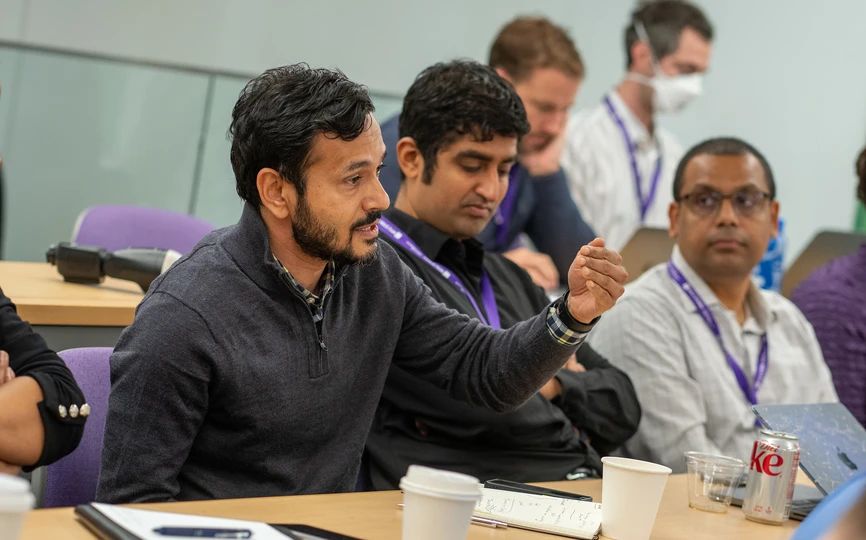 deepak hedge speaking at desk