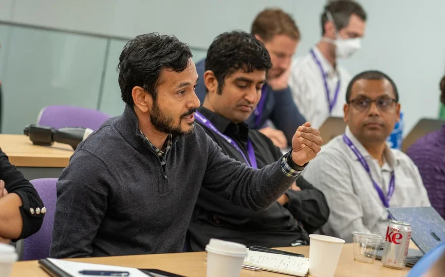deepak hedge speaking at desk