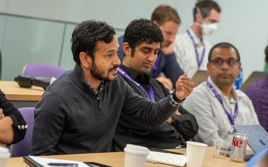 deepak hedge speaking at desk