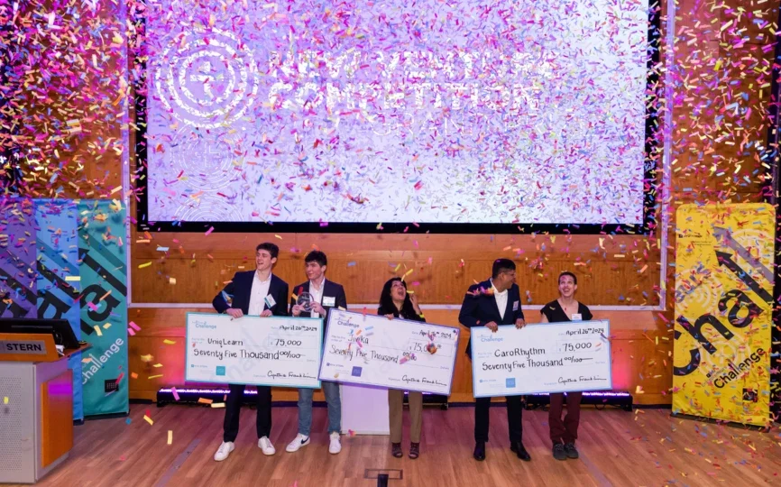 winners of the entrepreneurs challenge holding prize checks with confetti falling down
