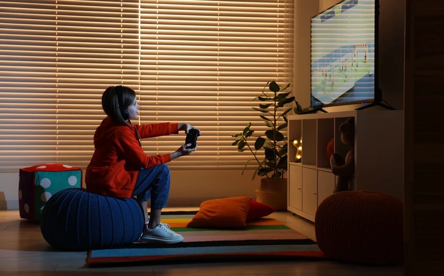 A child sitting in a darkened room playing a video game